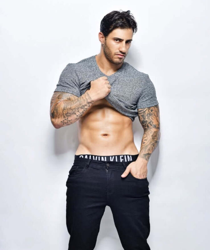ripped male entertainer lifting shirt to reveal chiselled abs